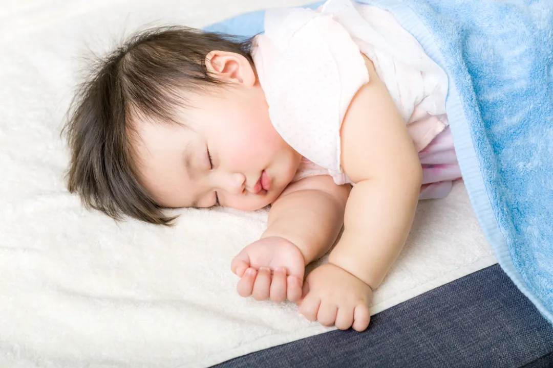 Un bébé dormant paisiblement sous une couverture douce